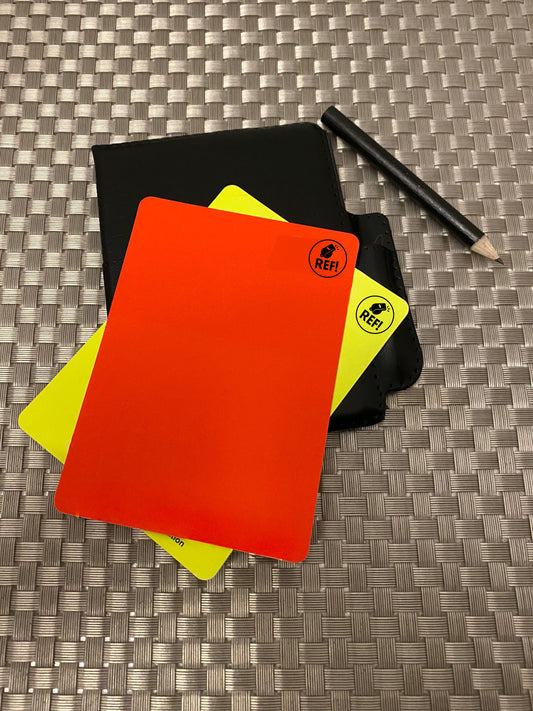 Referee cards with orange and yellow cards and Apple Pencil on textured surface